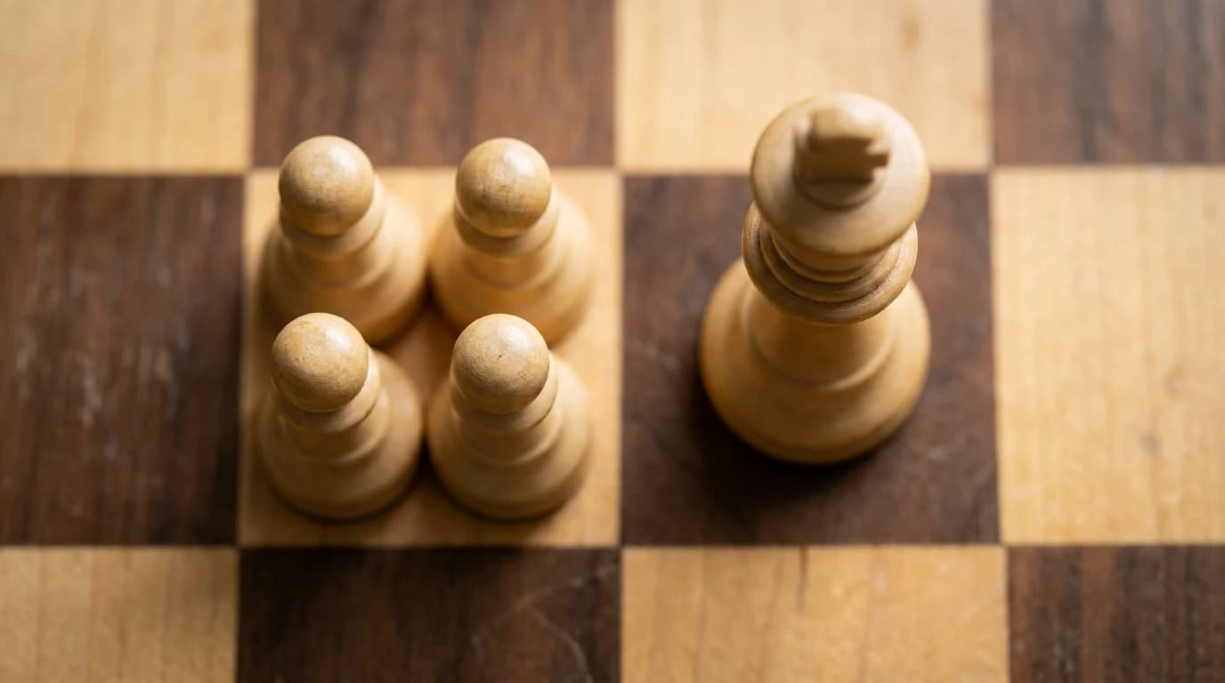 Four white wooden pawns standing with their bases touching, filling one light square of a wooden chessboard, with a white king on the neighbouring dark square for scale.